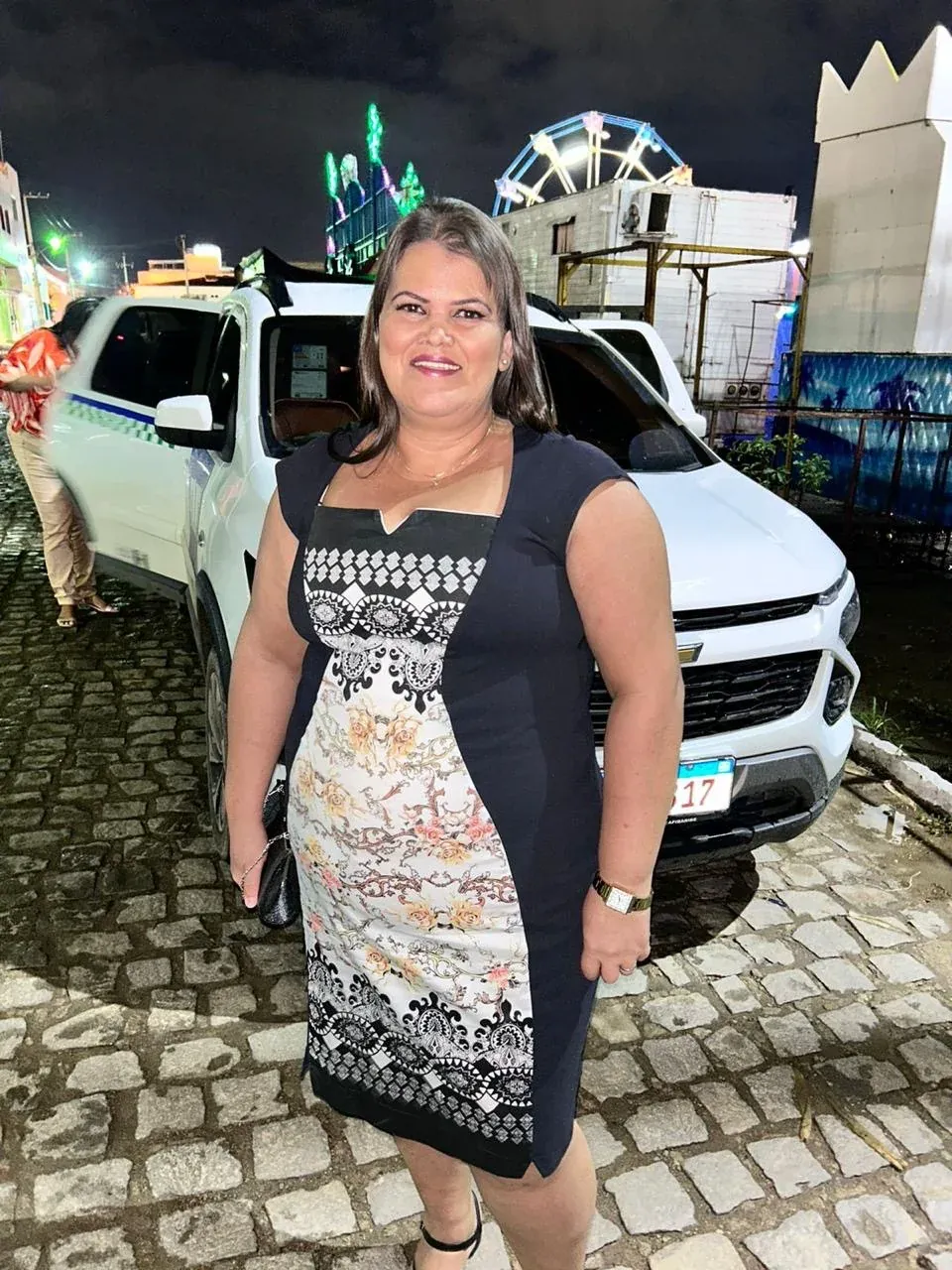 Clécia ao lado de sua Spin Premier branca, em foto do site Clécia Taxista